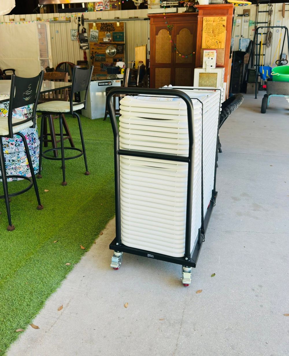 White folding chairs stacked on our rolling delivery cart, cleaned and ready for delivery